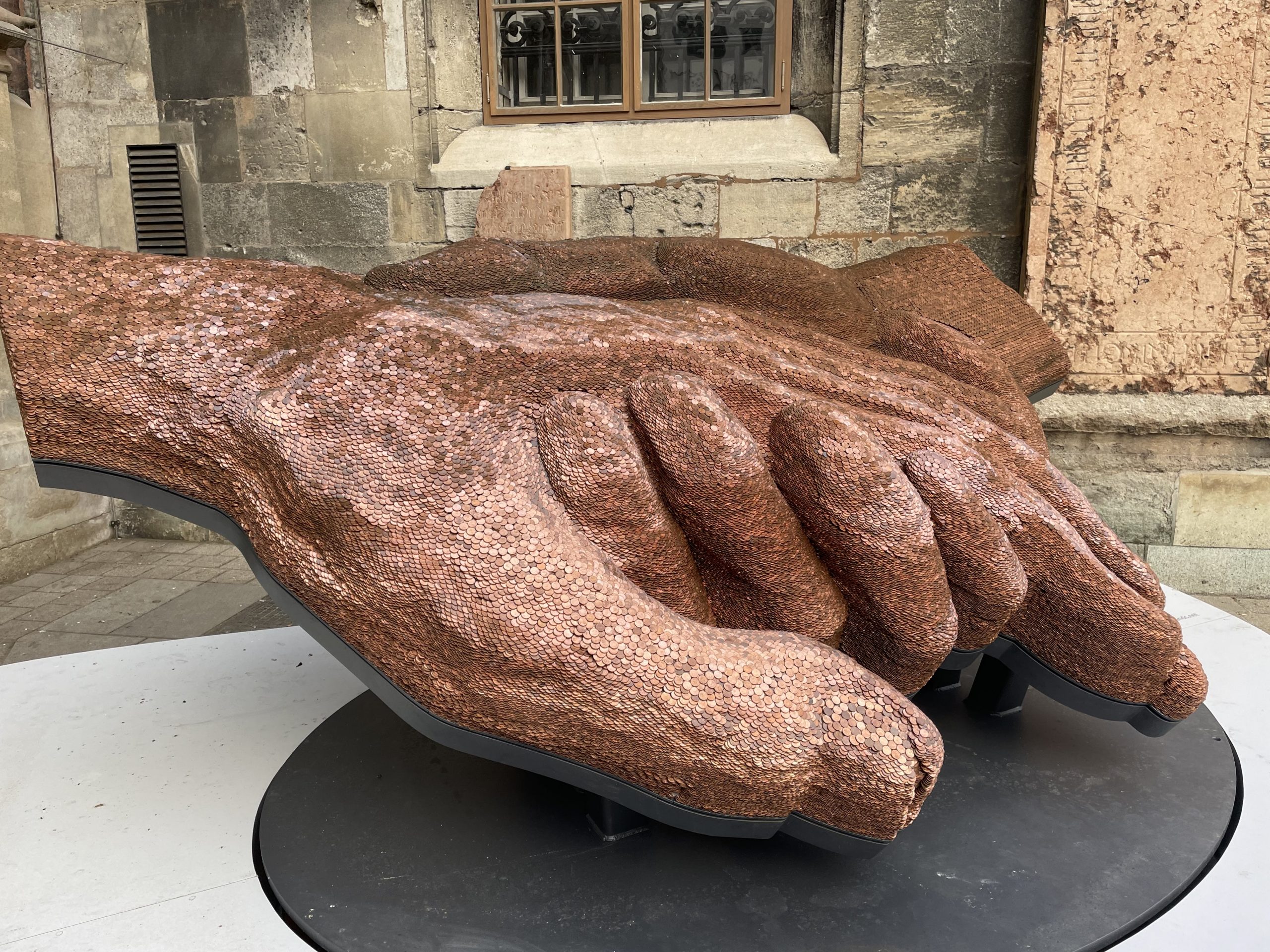 Skulptur mit zwei Händen aus Münzen